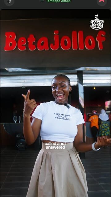 VA laughing outside a Beta Jollof restaurant