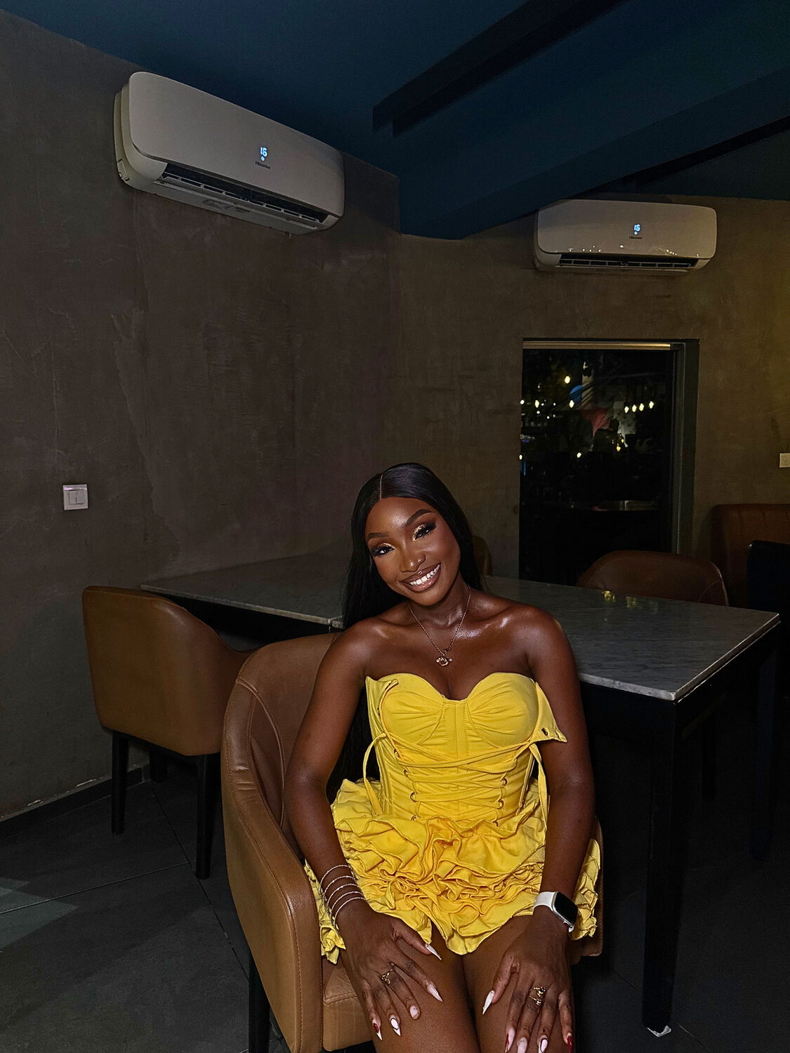 VA in a yellow dress in a lounge